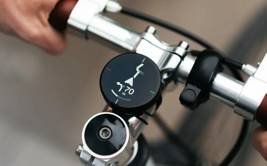 Publicity photo of Beeline Velo 2 mounted to a bicycle's handlebars, with the device showing navigation instructions